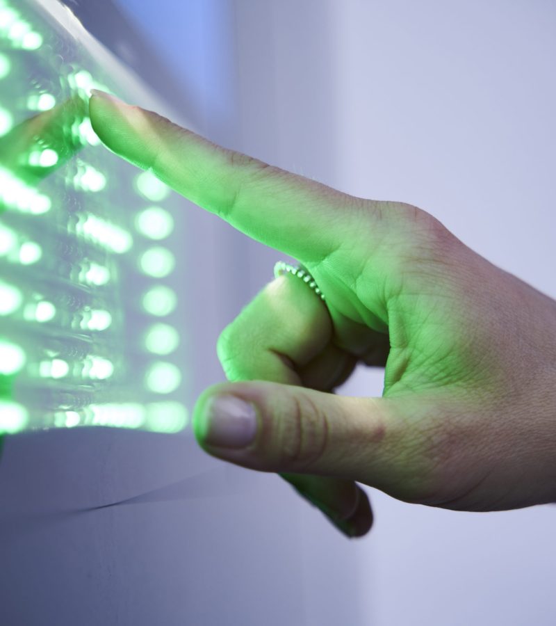 Detail of finger touching green led touchscreen